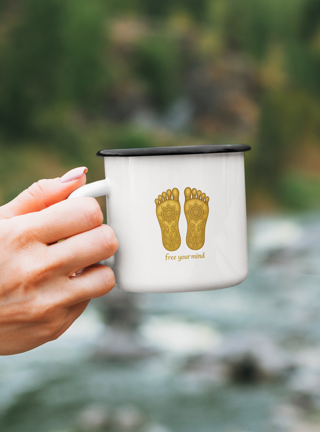 Buddhas Fußabdruck Tasse mit goldenen Fußabdrücken, ideal für entspannende Momente in der Natur.