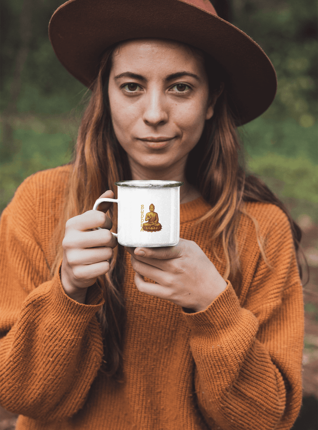 Frau mit einem Becher in der Hand, der eine Golden Buddha Tasse darstellt, im Freien mit herbstlichem Hintergrund.