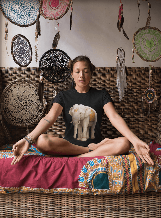 Frau meditiert in elegantem Ambiente, trägt ein Weißer Elefant Damen T-Shirt mit majestätischem Elefantenmotiv.