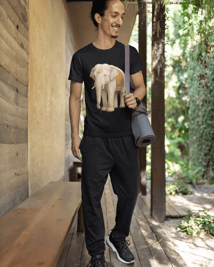 Mann trägt Weißer Elefant Herren T-Shirt, lächelnd in entspannter Umgebung mit Yogamatte.